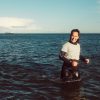 Nadia standing in the ocean smiling.