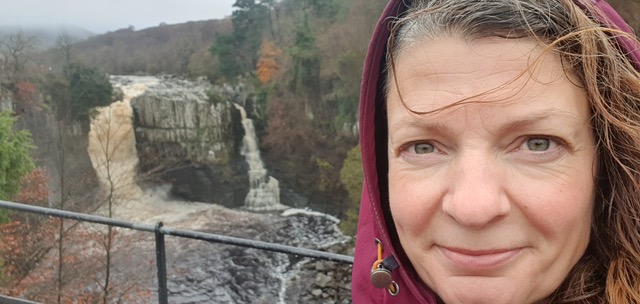 A portrait of Emma smiling with waterfalls in the background